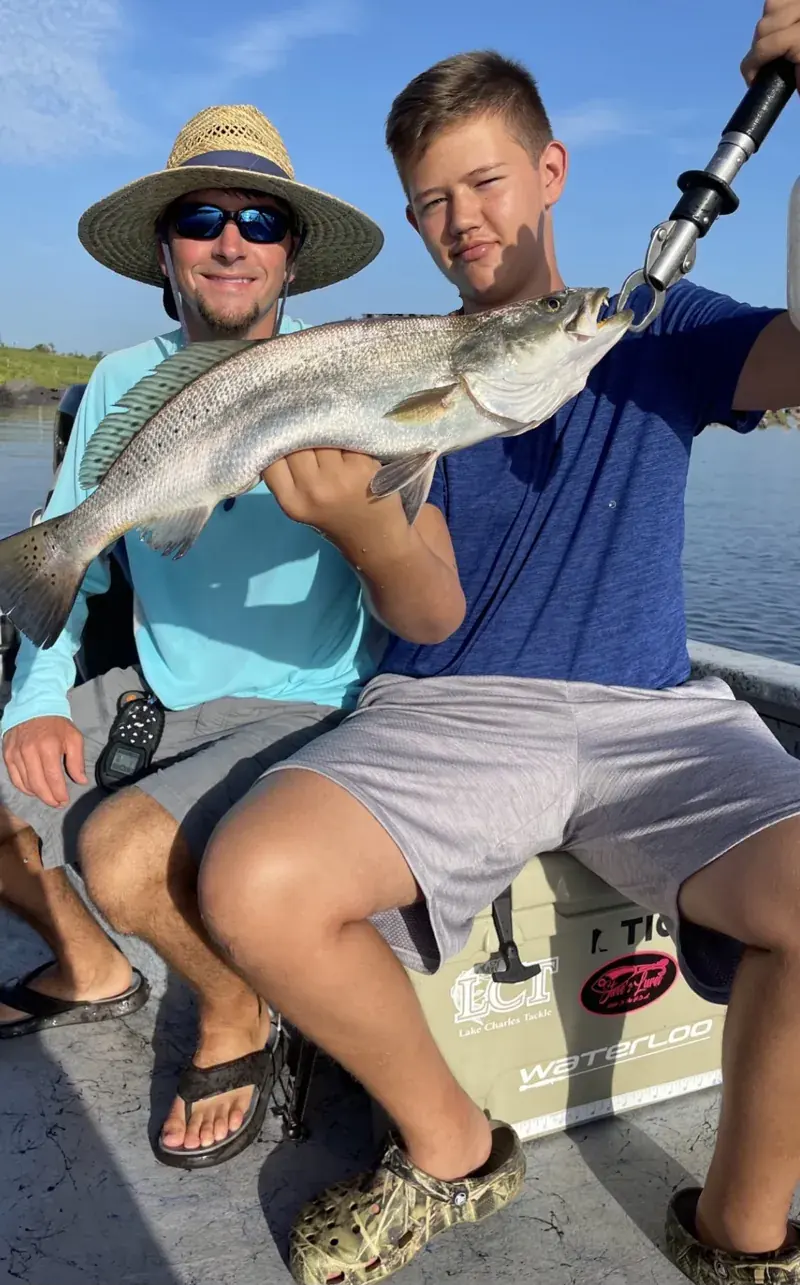 Captain Conlon with a young angler holding a large speckled trout