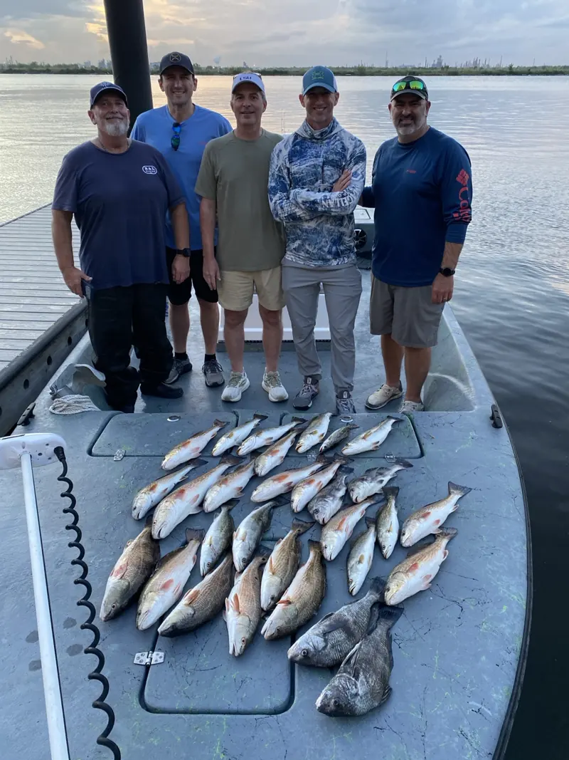 Five anglers aboard the boat with their catch at sunset