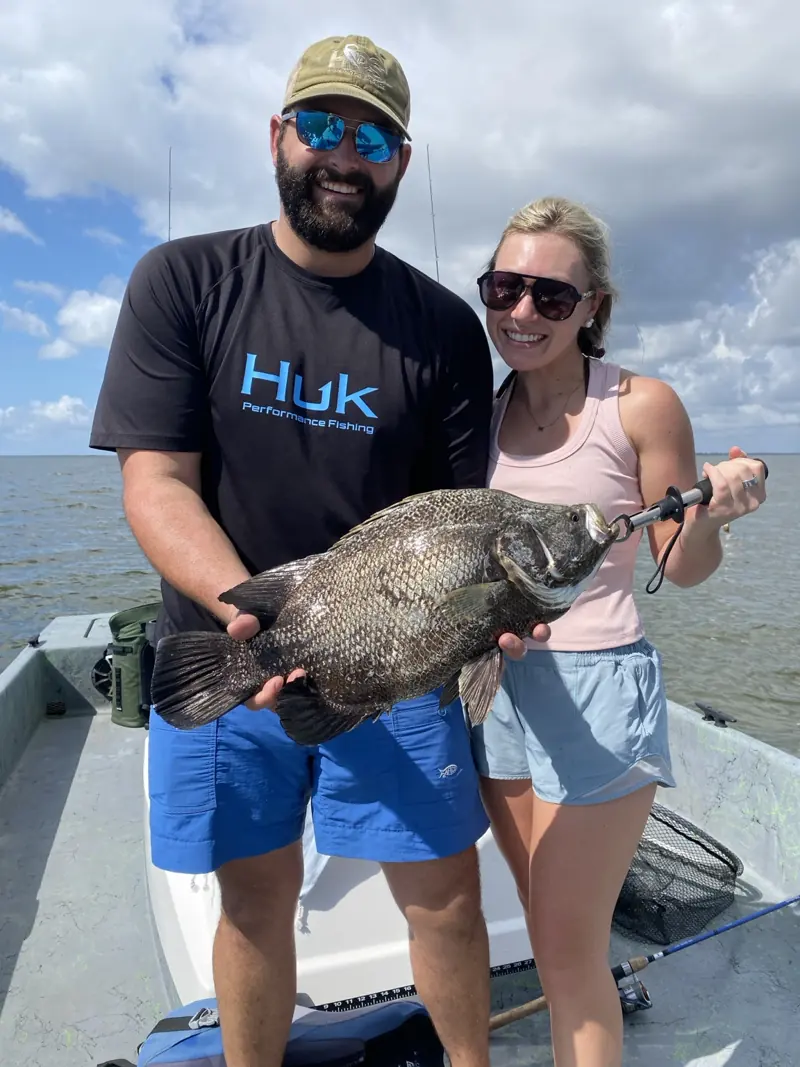Two clients holding a large black drum